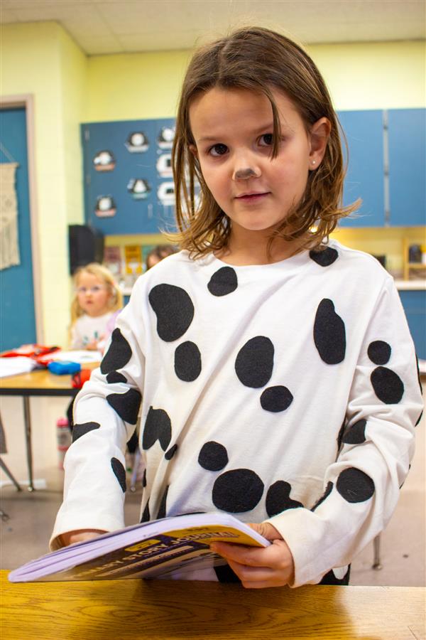 girl dressed as dalmatian dog with book